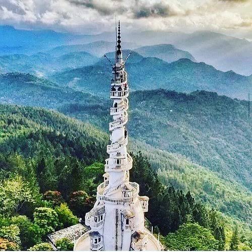 Ambuluwawa Tower spiral staircase rising above misty green hills in Sri Lanka